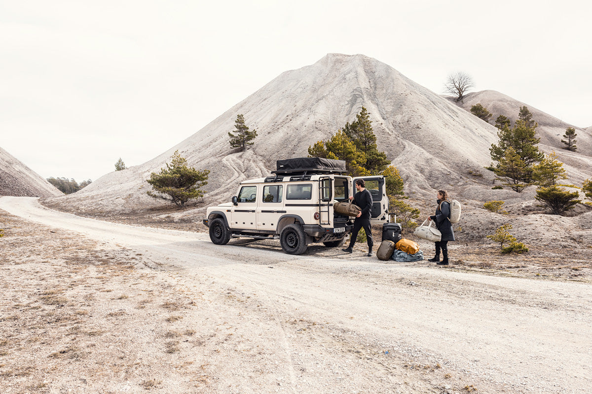 Two people with a vehicle in a mountainous area