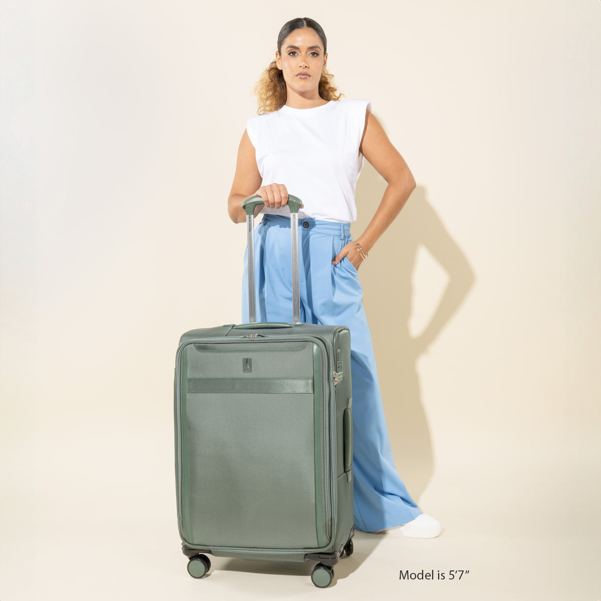 Travelpro VersaPack+ Medium Check-In Spinner in Desert Sage Green — lifestyle