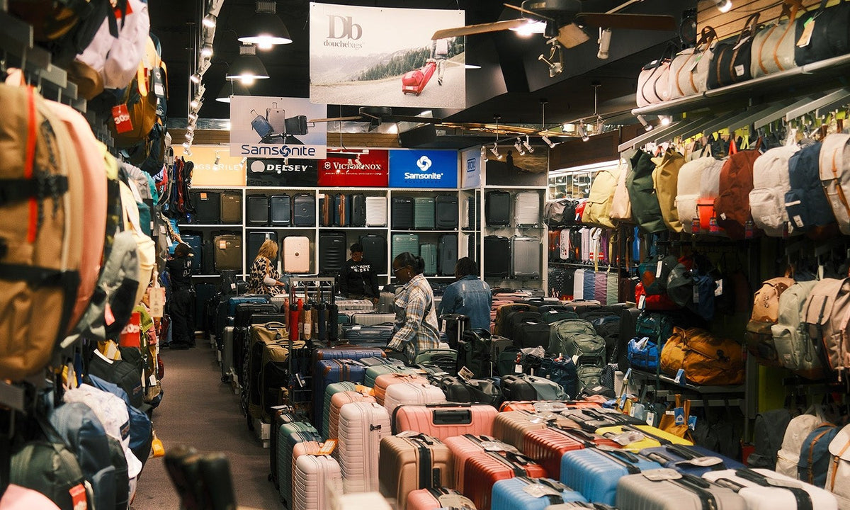 Inside Empire Luggage Center at 414 Broadway: aisle of suitcases and backpacks