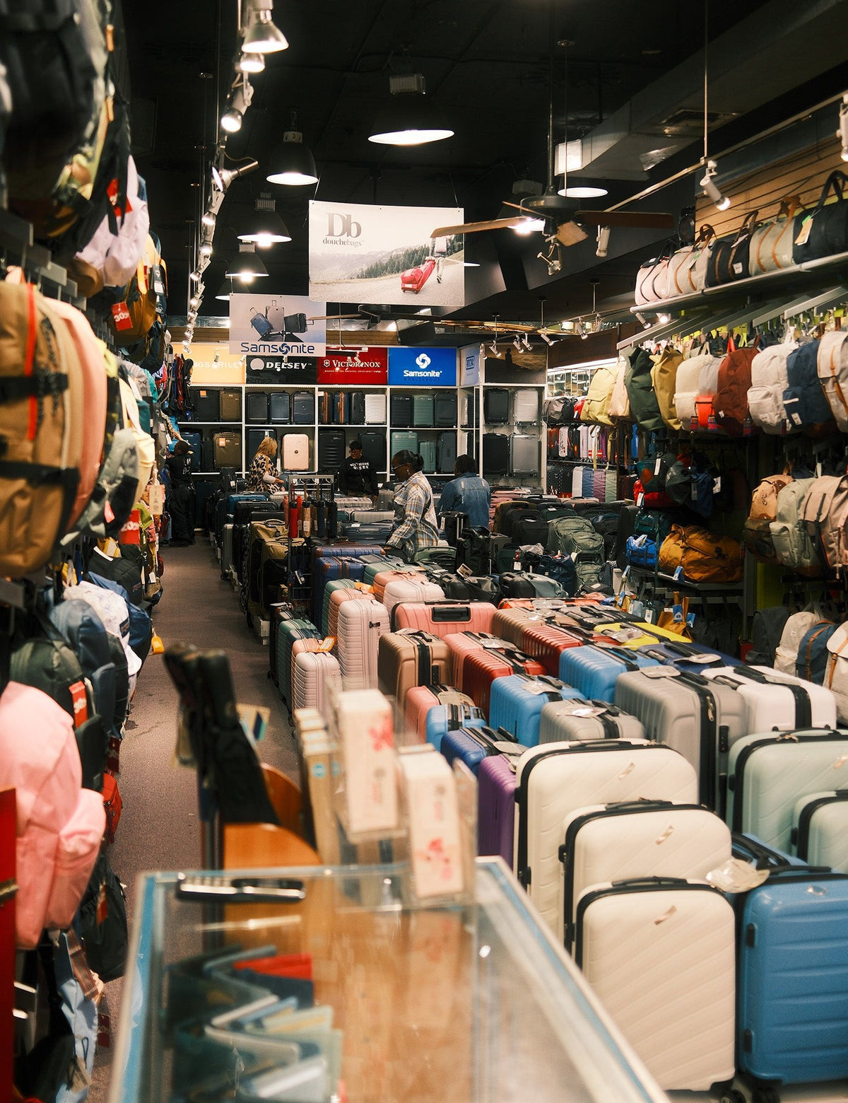 Inside Empire Luggage Center at 414 Broadway: aisle of suitcases and backpacks