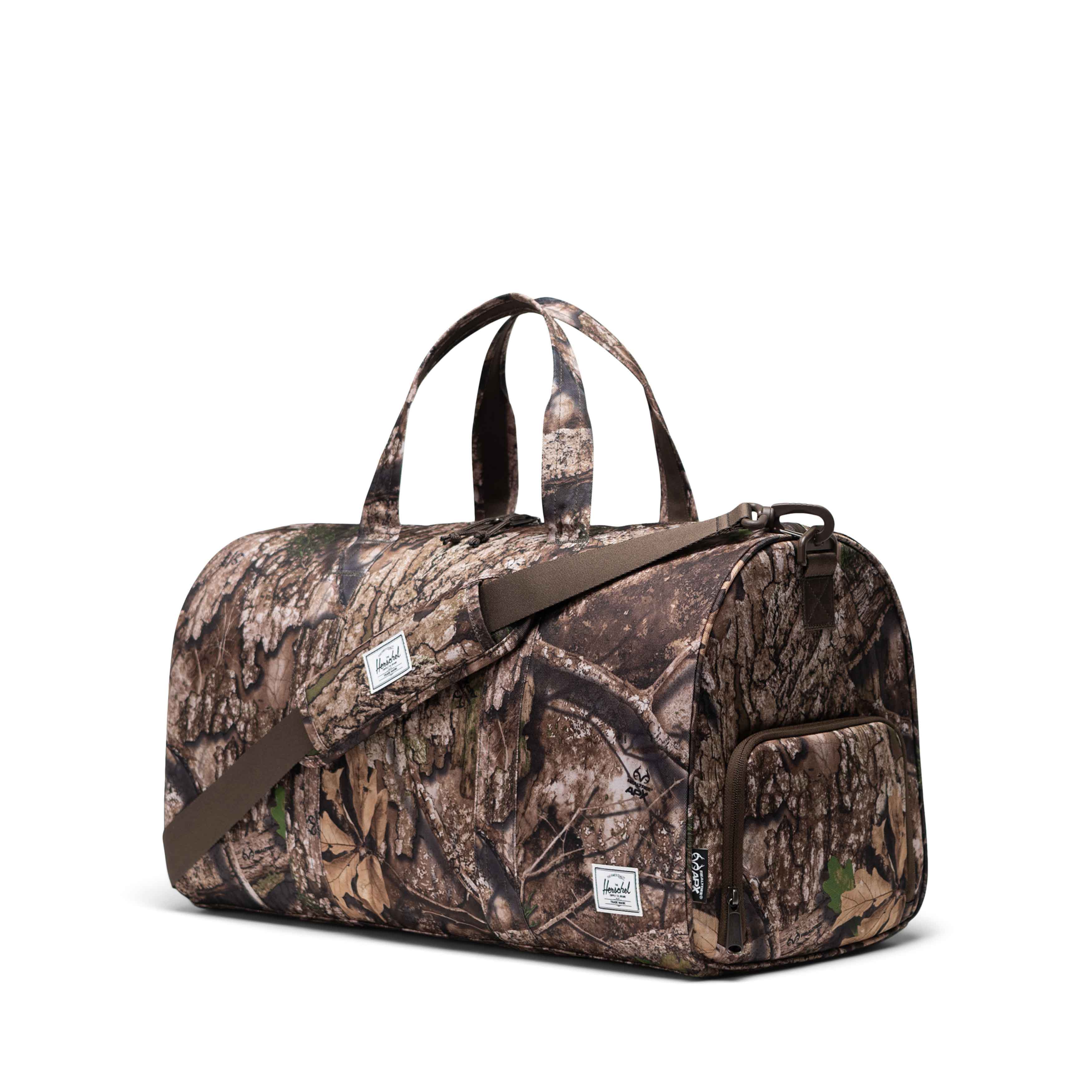 Realtree Herschel Novel Duffle 43L in Realtree APX™ Camo — angle view 2